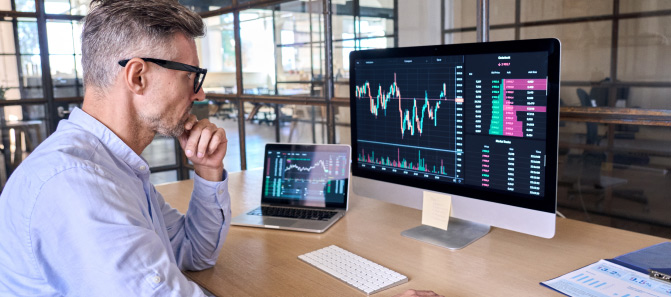 Professional sitting at computer and analyzing crypto data.