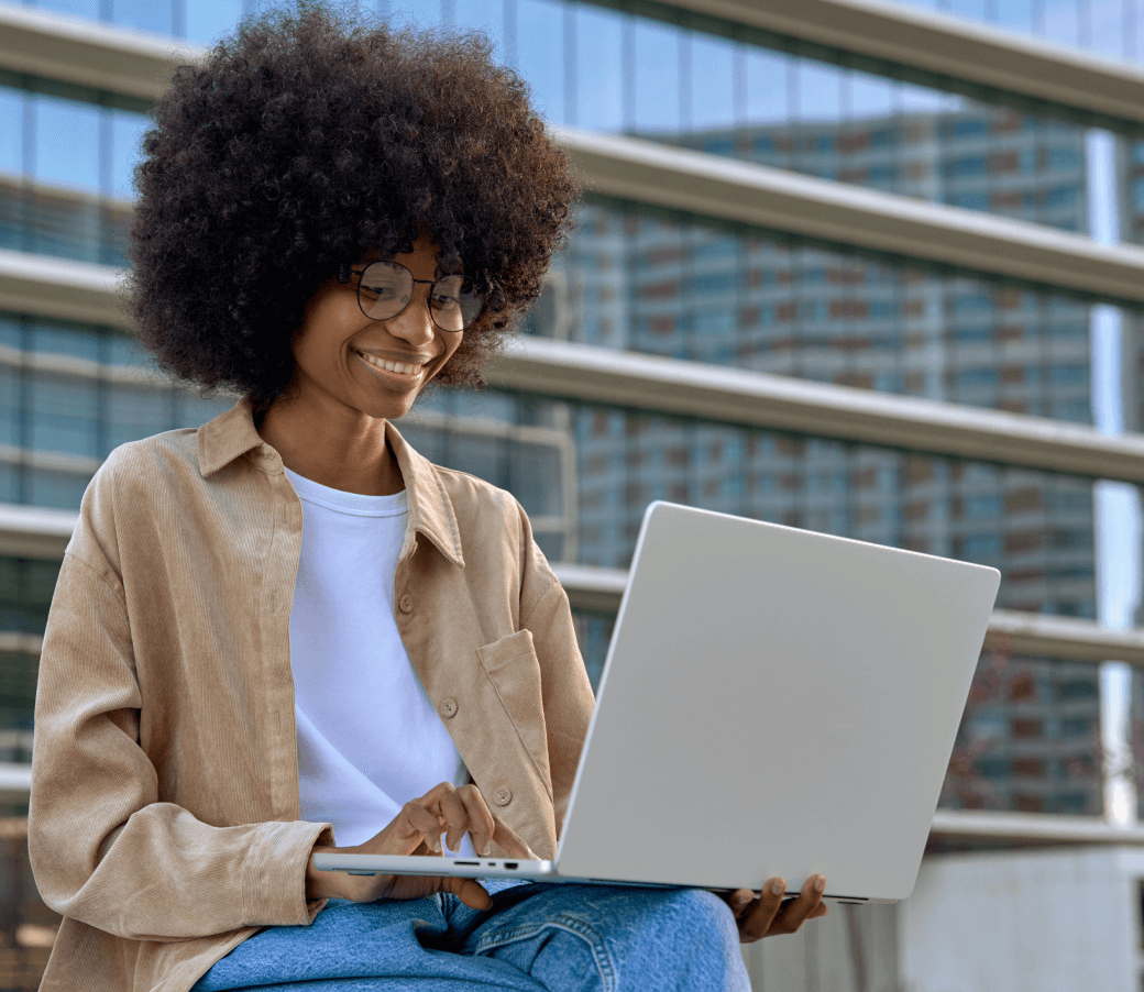 Woman sitting outside on laptop utilizing an AI-enabled personal computer.