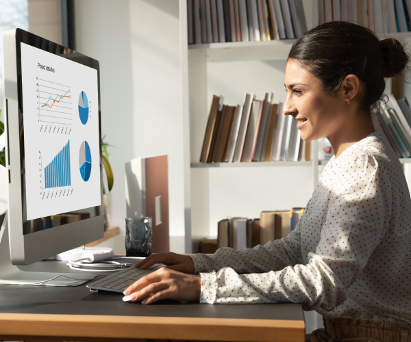 Woman sitting at computer and analyzing financial data on an agentic AI-driven platform.