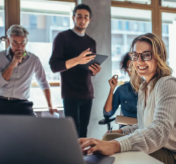 Professional team working together on AI data readiness roadmap, sitting around computer.